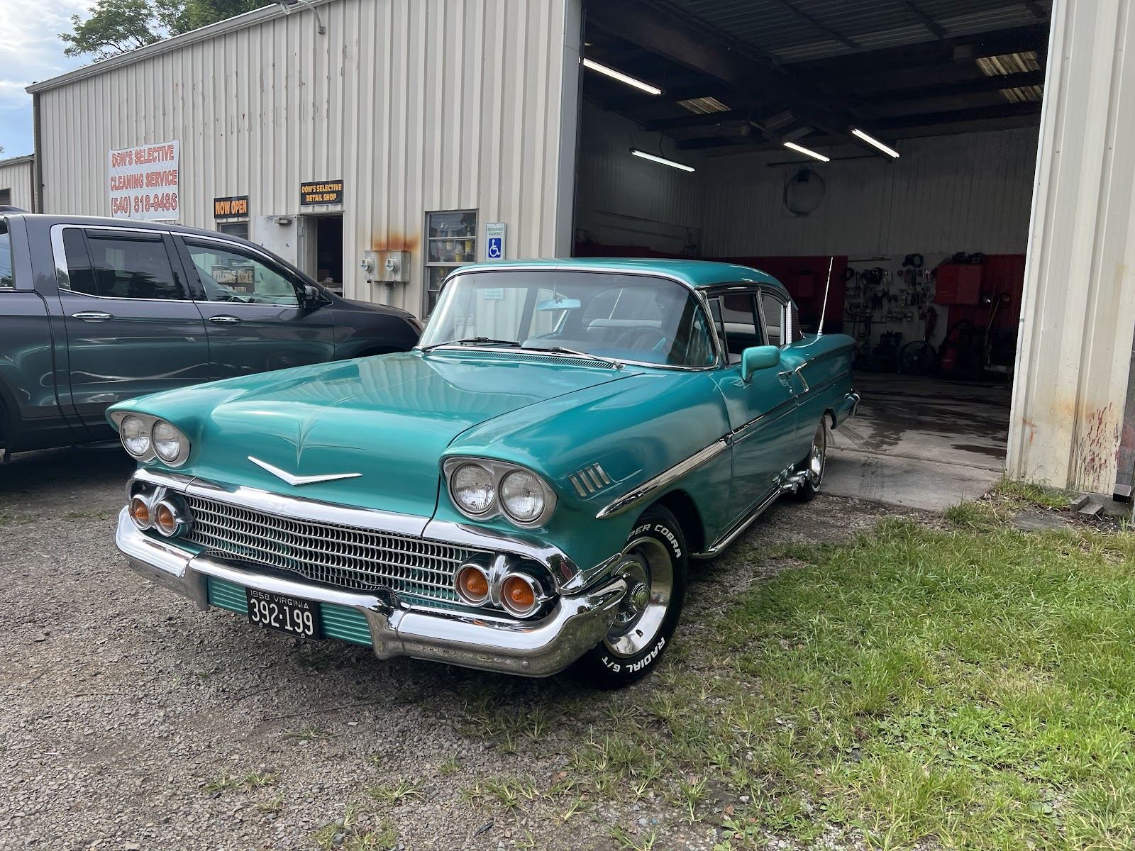Restored teal 1958 Chevrolet parked outside the shop after detailing