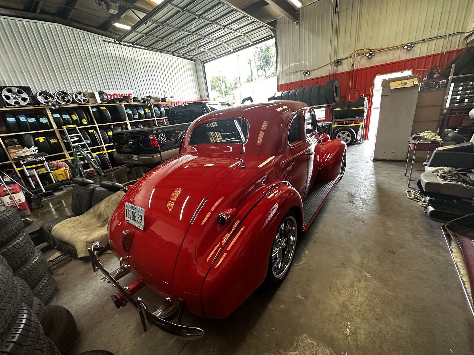Classic red hot rod coupe polished to a mirror shine inside the shop