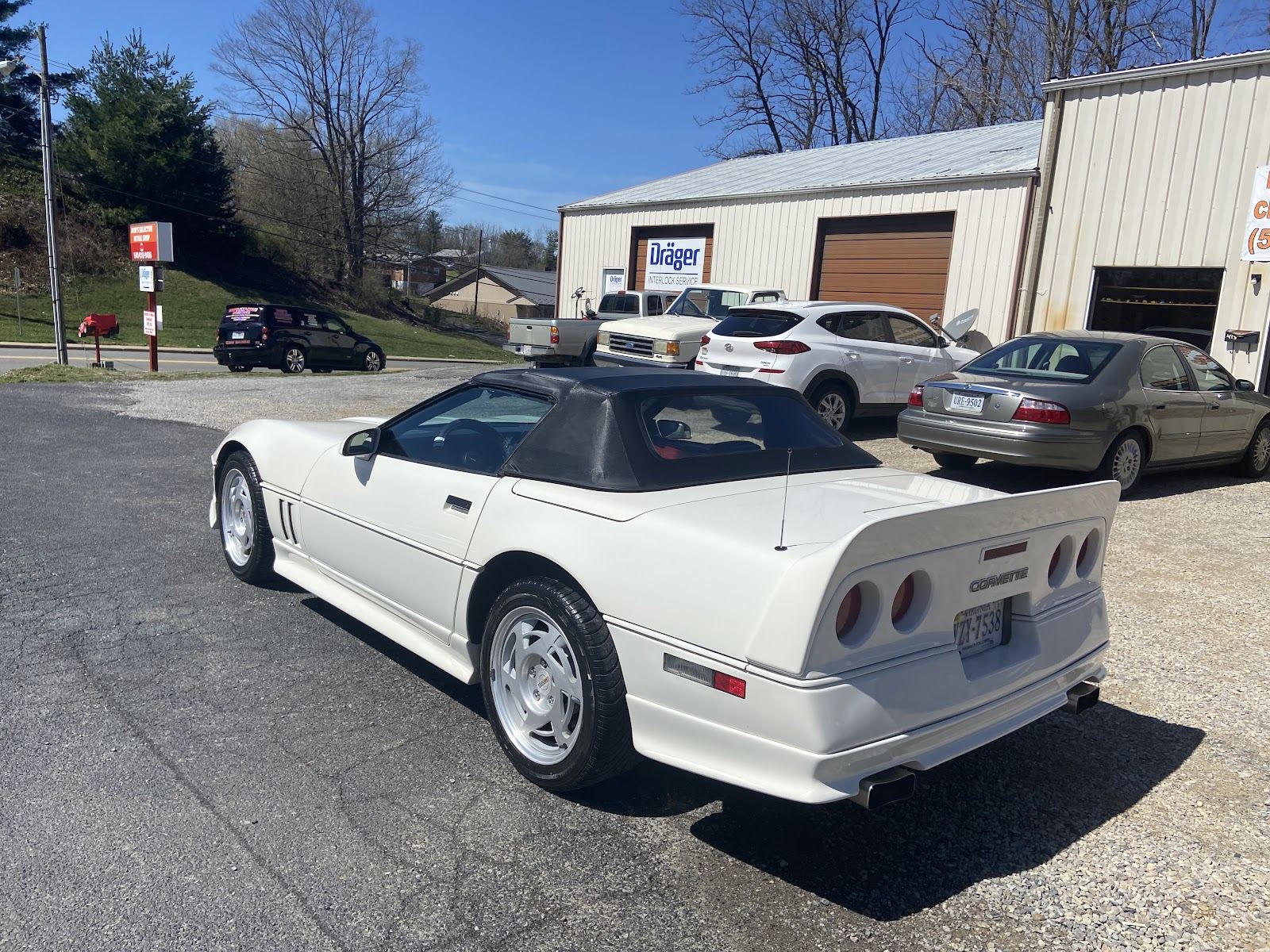White Chevrolet Corvette convertible after a full hand detail, parked outside the shop