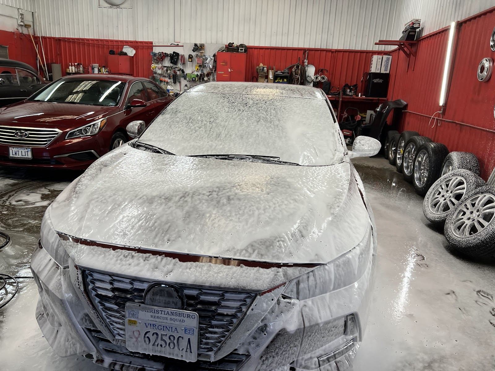 A vehicle covered in thick foam during a hand wash at Dow's Auto Detailing