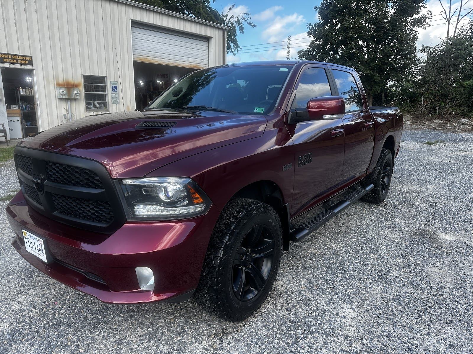 Maroon Dodge Ram 1500 pickup truck after a full hand detail, parked outside Dow's Auto Detailing